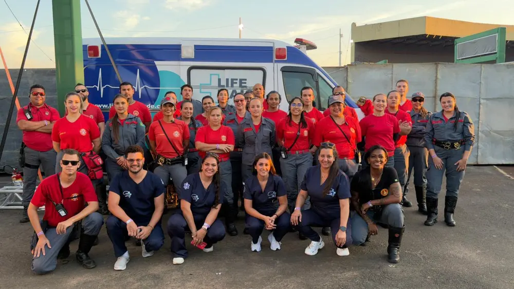 Equipe completa da Life Mais Saúde — socorristas, bombeiros civis, enfermagem e equipe médica em frente à ambulância